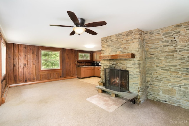 2765 Tater Ridge Rd, West Union, OH 45693 - unfurnished living room with a ceiling fan, light colored carpet, a fireplace, and wooden walls