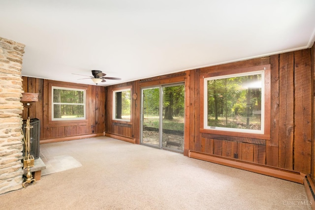 2765 Tater Ridge Rd, West Union, OH 45693 - unfurnished living room featuring a baseboard heating unit, wooden walls, carpet, a baseboard radiator, and a ceiling fan