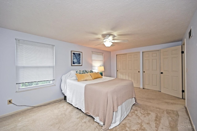 3016 Stratford Ct Unit 115, Cincinnati, OH 45140 - bedroom featuring two closets, light colored carpet, a ceiling fan, and a textured ceiling
