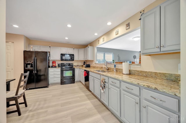 3435 Kleeman Lake Ct, Cincinnati, OH 45211 - kitchen featuring black appliances, light wood-style floors, recessed lighting, and light stone counters