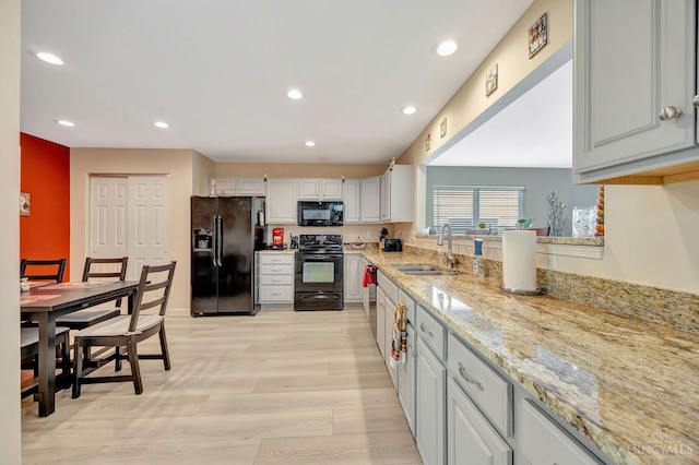 3435 Kleeman Lake Ct, Cincinnati, OH 45211 - kitchen with black appliances, light wood finished floors, recessed lighting, light stone countertops, and white cabinetry