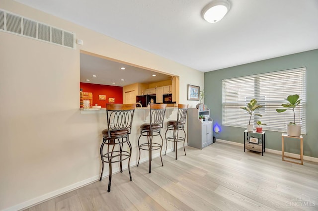 3435 Kleeman Lake Ct, Cincinnati, OH 45211 - kitchen featuring freestanding refrigerator, light wood-style floors, a breakfast bar, a peninsula, and recessed lighting