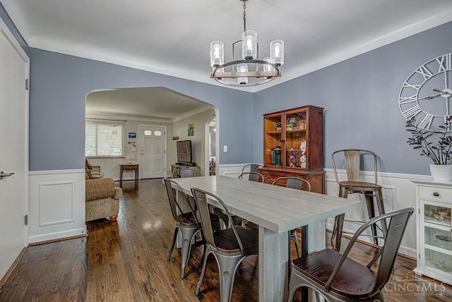 4213 Alex Ave, Cheviot, OH 45211 - dining area featuring arched walkways, wainscoting, a chandelier, dark wood-style flooring, and a decorative wall