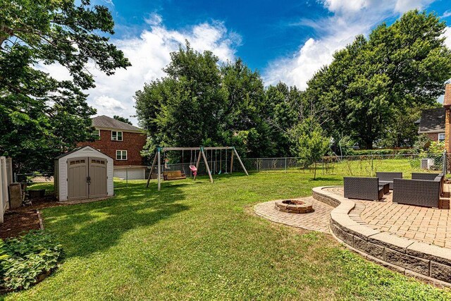 4213 Alex Ave, Cheviot, OH 45211 - fenced backyard featuring a playground, a storage shed, a patio area, and an outdoor living space with a fire pit