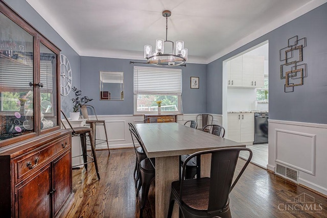 4213 Alex Ave, Cheviot, OH 45211 - dining space with a chandelier, a wainscoted wall, dark wood-type flooring, and a decorative wall