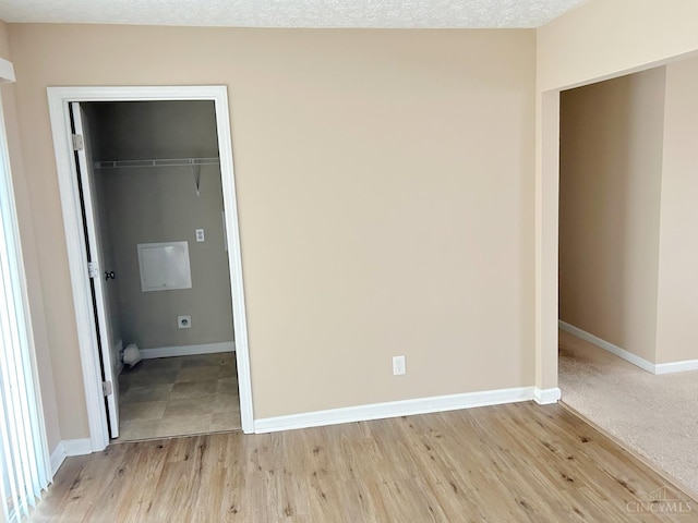 2247 Tucker Rd, Blanchester, OH 45107 - unfurnished bedroom with a walk in closet and light wood-style flooring
