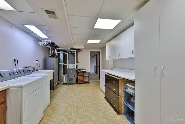 5681 Thomaridge Ct, Green Twp, OH 45248 - washroom with cabinet space, washing machine and dryer, gas water heater, light flooring, and heating unit