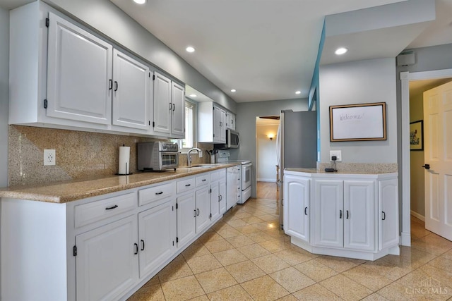5681 Thomaridge Ct, Green Twp, OH 45248 - kitchen featuring white electric range oven, stainless steel microwave, white cabinets, tasteful backsplash, and recessed lighting