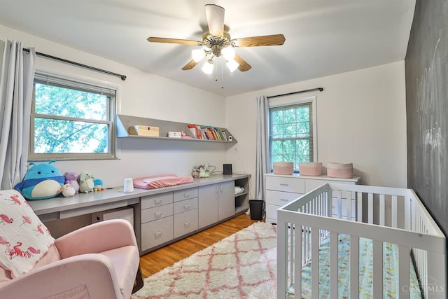 5681 Thomaridge Ct, Green Twp, OH 45248 - bedroom featuring multiple windows, light wood finished floors, a nursery area, and ceiling fan