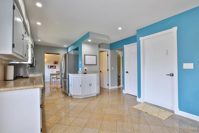 5681 Thomaridge Ct, Green Twp, OH 45248 - kitchen with white cabinets, light countertops, freestanding refrigerator, recessed lighting, and granite tiled floors