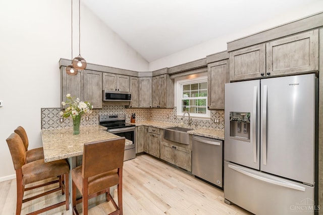 3008 State Route 133, Bethel, OH 45106 - kitchen with stainless steel appliances, a peninsula, light wood-style flooring, light stone countertops, and tasteful backsplash