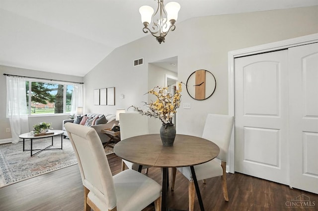 8135 Faller Rd, Hamilton Twp, OH 45039 - dining area with vaulted ceiling, dark wood-style flooring, and a chandelier