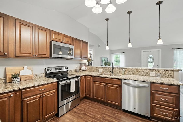 8135 Faller Rd, Hamilton Twp, OH 45039 - kitchen with stainless steel appliances, vaulted ceiling, a peninsula, dark wood-style floors, and decorative light fixtures