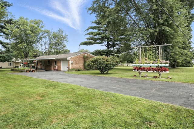 8135 Faller Rd, Hamilton Twp, OH 45039 - view of grassy yard featuring a carport and asphalt driveway
