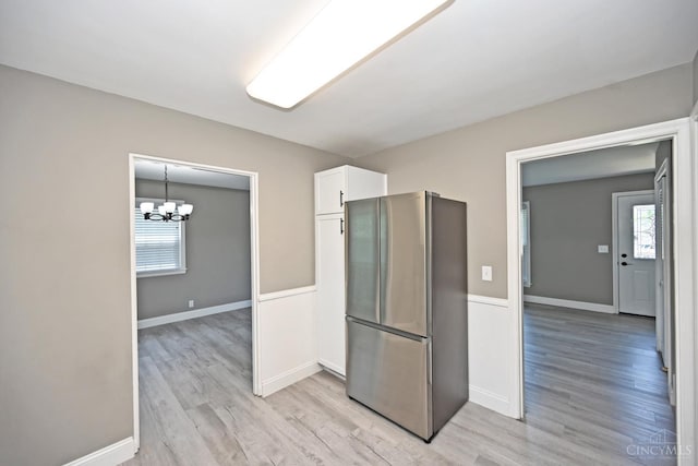 64 Craig Dr, Hamilton, OH 45013 - kitchen with freestanding refrigerator, light wood-type flooring, white cabinets, and a chandelier