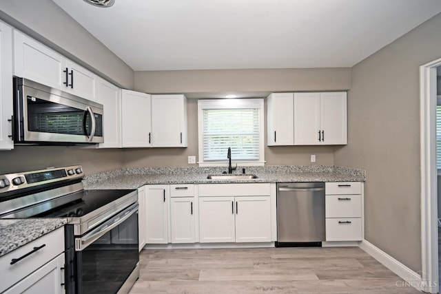 64 Craig Dr, Hamilton, OH 45013 - kitchen featuring stainless steel appliances, light wood finished floors, white cabinetry, and light stone countertops