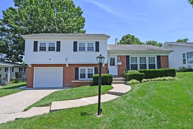 64 Craig Dr, Hamilton, OH 45013 - split level home with a garage, brick siding, a front yard, and driveway