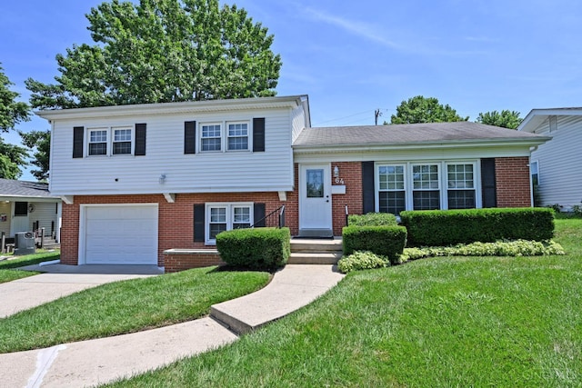 64 Craig Dr, Hamilton, OH 45013 - split level home featuring a garage, brick siding, driveway, and a front lawn