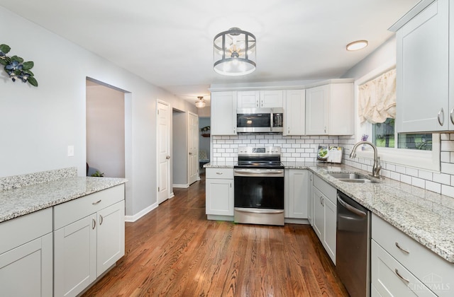 3340 Algus Ln, Green Twp, OH 45248 - kitchen featuring stainless steel appliances, backsplash, dark wood-style floors, and light stone counters