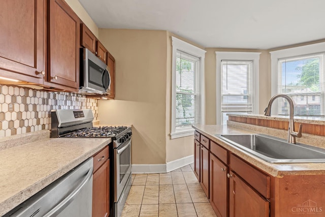 5824 Saranac Ave, Cincinnati, OH 45224 - kitchen with appliances with stainless steel finishes, backsplash, brown cabinetry, light countertops, and light tile patterned floors