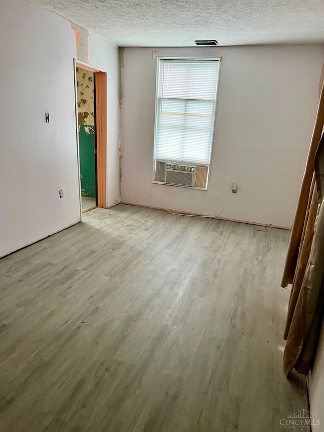 202 E 2nd St, Georgetown, OH 45121 - empty room with cooling unit, a textured ceiling, and wood finished floors