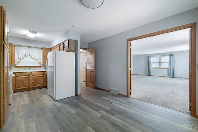 27 N Breiel, Middletown, OH 45042 - kitchen featuring freestanding refrigerator, light wood-style floors, brown cabinets, light countertops, and range