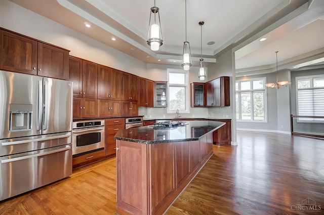 4994 Maxwell Dr, Mason, OH 45040 - kitchen featuring appliances with stainless steel finishes, a raised ceiling, light wood-style flooring, dark stone countertops, and recessed lighting