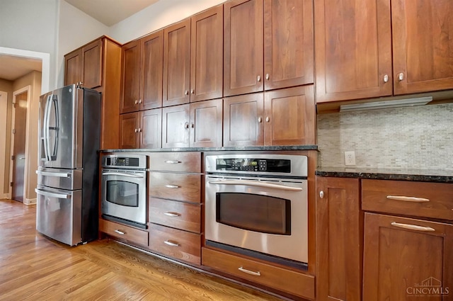 4994 Maxwell Dr, Mason, OH 45040 - kitchen featuring appliances with stainless steel finishes, brown cabinets, tasteful backsplash, and light wood-type flooring