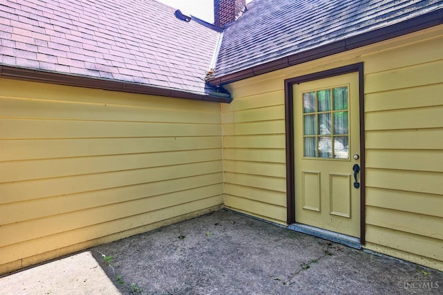 5868 Greenlawn Rd, Fairfield Twp, OH 45011 - view of exterior entry with roof with shingles and a chimney