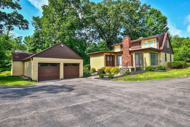 5868 Greenlawn Rd, Fairfield Twp, OH 45011 - view of front facade featuring an outbuilding, a chimney, asphalt driveway, and an attached garage