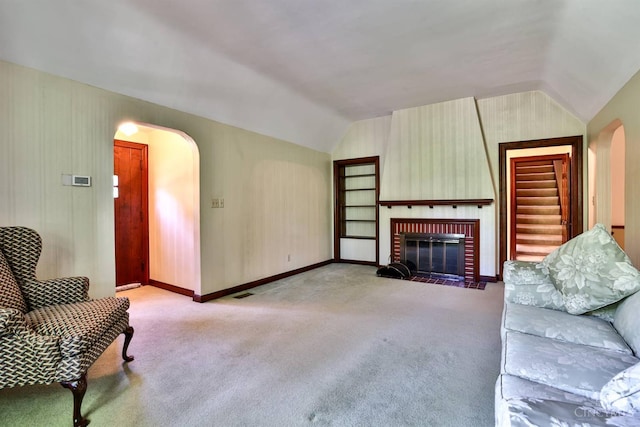 5868 Greenlawn Rd, Fairfield Twp, OH 45011 - living area with arched walkways, vaulted ceiling, carpet floors, and a fireplace