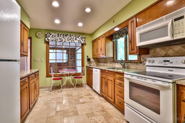5868 Greenlawn Rd, Fairfield Twp, OH 45011 - kitchen featuring white appliances, tasteful backsplash, brown cabinets, light stone finish floors, and recessed lighting