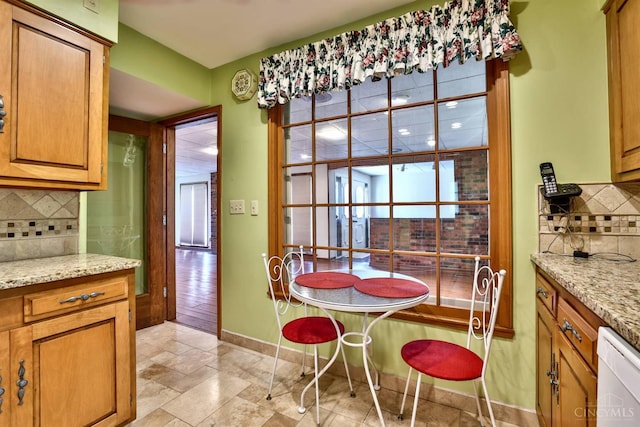5868 Greenlawn Rd, Fairfield Twp, OH 45011 - kitchen with dishwasher, decorative backsplash, light stone counters, and brown cabinetry