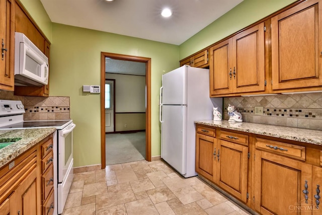 5868 Greenlawn Rd, Fairfield Twp, OH 45011 - kitchen featuring white appliances, brown cabinetry, tasteful backsplash, light stone finish floors, and light stone counters