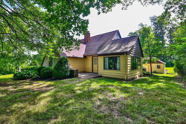 5868 Greenlawn Rd, Fairfield Twp, OH 45011 - rear view of house with a chimney, a lawn, and roof with shingles
