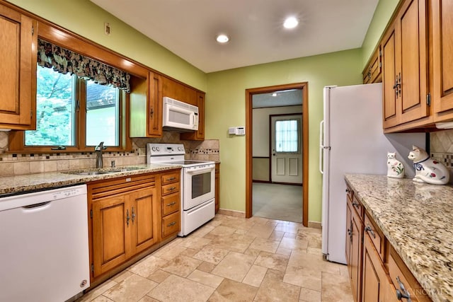 5868 Greenlawn Rd, Fairfield Twp, OH 45011 - kitchen with white appliances, backsplash, brown cabinetry, plenty of natural light, and recessed lighting