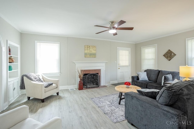 1744 Northampton Dr, Cincinnati, OH 45237 - living area featuring light wood-type flooring, healthy amount of natural light, a ceiling fan, ornamental molding, and a brick fireplace