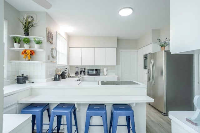 1744 Northampton Dr, Cincinnati, OH 45237 - kitchen with stainless steel fridge with ice dispenser, a peninsula, tasteful backsplash, light wood finished floors, and white cabinetry