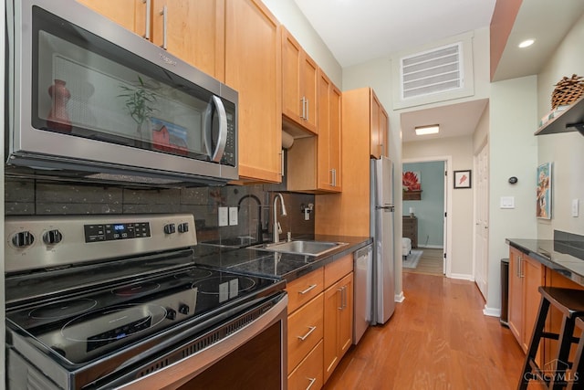 2100 Sinton Ave Unit 2, Cincinnati, OH 45206 - kitchen with stainless steel appliances, light wood-style flooring, backsplash, dark countertops, and recessed lighting