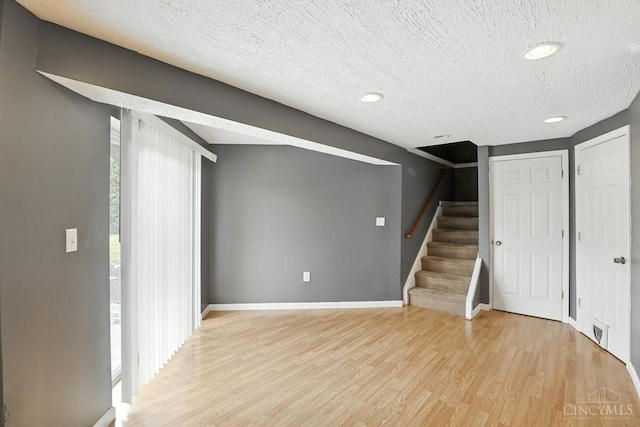 2317 Garrison Dr, Springfield Twp, OH 45231 - below grade area with light wood finished floors, stairs, a textured ceiling, and recessed lighting