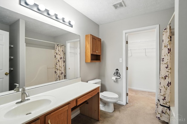 8939 Perry Ave, Franklin, OH 45005 - bathroom featuring vanity, curtained shower, a textured ceiling, and a walk in closet