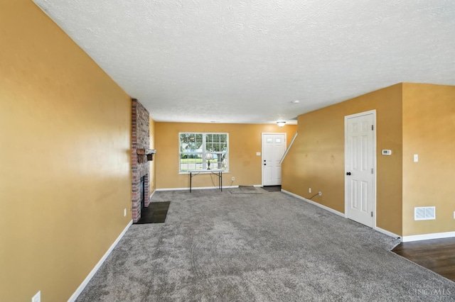 8939 Perry Ave, Franklin, OH 45005 - unfurnished living room with a textured ceiling, carpet floors, and a brick fireplace