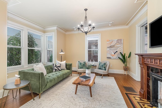 1117 Cypress St, Cincinnati, OH 45206 - living area featuring wood finished floors, a chandelier, a fireplace with flush hearth, and crown molding
