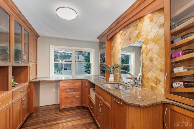 1117 Cypress St, Cincinnati, OH 45206 - kitchen featuring brown cabinetry, light stone countertops, dark wood-style floors, and glass insert cabinets