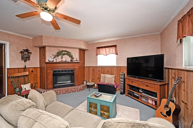 7423 View Place Dr, Springfield Twp, OH 45224 - living area featuring wood walls, a wainscoted wall, carpet floors, a fireplace, and a ceiling fan
