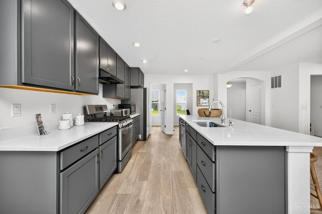 5322 Observer Ct, Turtle Creek Twp, OH 45036 - kitchen with appliances with stainless steel finishes, under cabinet range hood, arched walkways, light wood-style floors, and light countertops