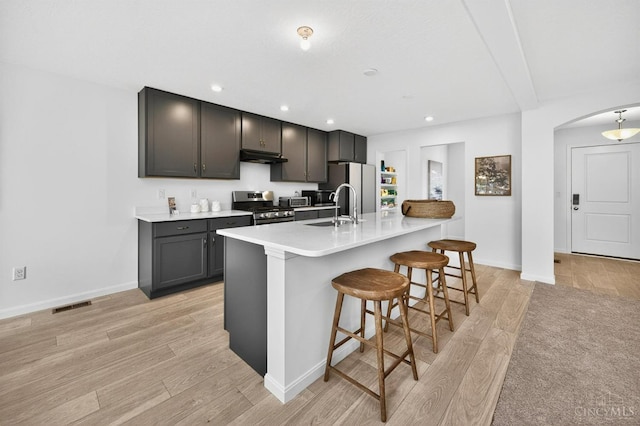 5322 Observer Ct, Turtle Creek Twp, OH 45036 - kitchen with gas stove, light wood-style flooring, under cabinet range hood, freestanding refrigerator, and recessed lighting