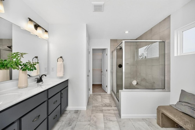 5322 Observer Ct, Turtle Creek Twp, OH 45036 - bathroom featuring double vanity, a stall shower, a walk in closet, marble finish flooring, and recessed lighting