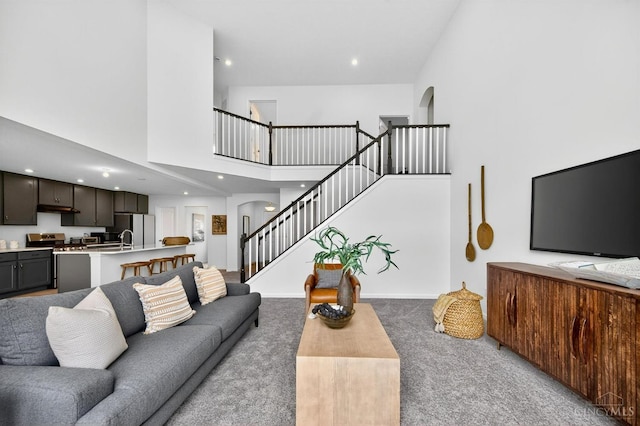 5322 Observer Ct, Turtle Creek Twp, OH 45036 - carpeted living room featuring a towering ceiling, stairs, arched walkways, and recessed lighting