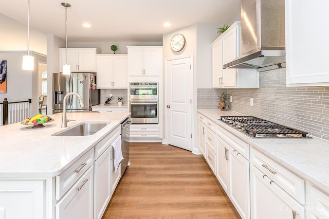 9302 W Meadow Dr, West Chester, OH 45069 - kitchen with wall chimney exhaust hood, stainless steel appliances, white cabinetry, a center island with sink, and recessed lighting